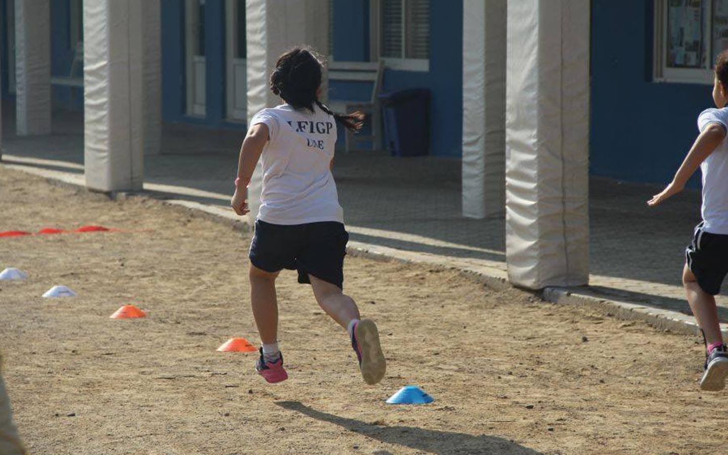 طلبة يركضون في الملعب الرياضي