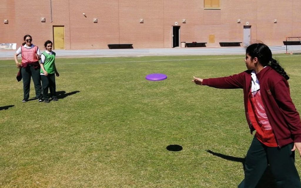 طالبات يلعبن في الملعب العشبي